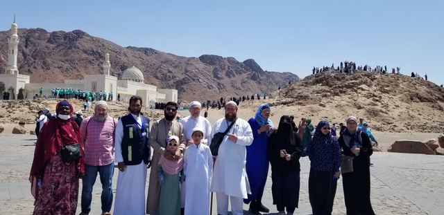 Amity Umrah group at Uhud with the Sayyid al-Shuhada Mosque and the mountain behind