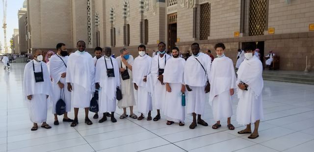 Amity Umrah group in ihram lined up outside a gate of Masjid an-Nabawi