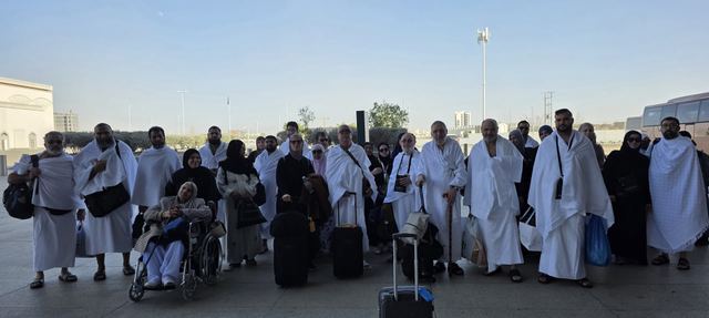 Amity Umrah group in ihram standing together with their luggage on arrival